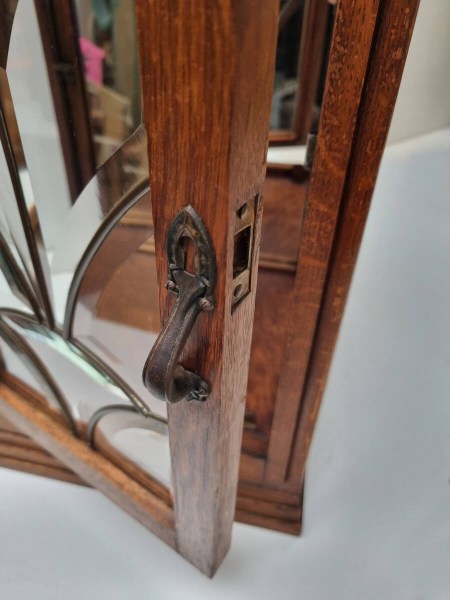 Metalen handvat en slot op de deur van een vintage eiken vitrinekast